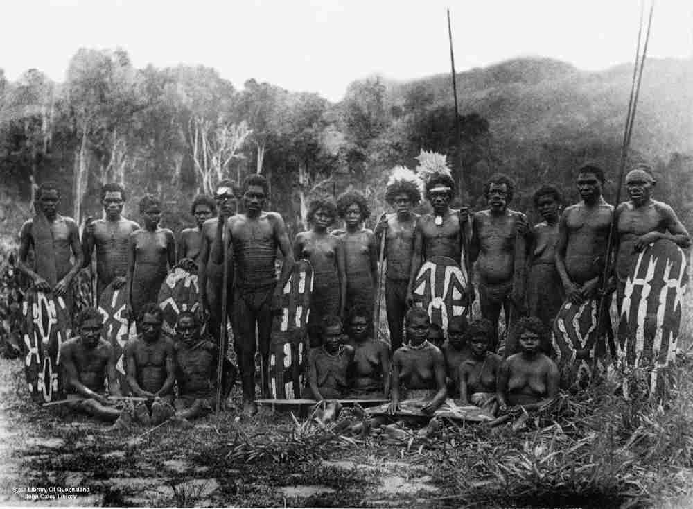 A group of rainforest aborigines with painted shields, 
spears, boomerangs and wooden swords