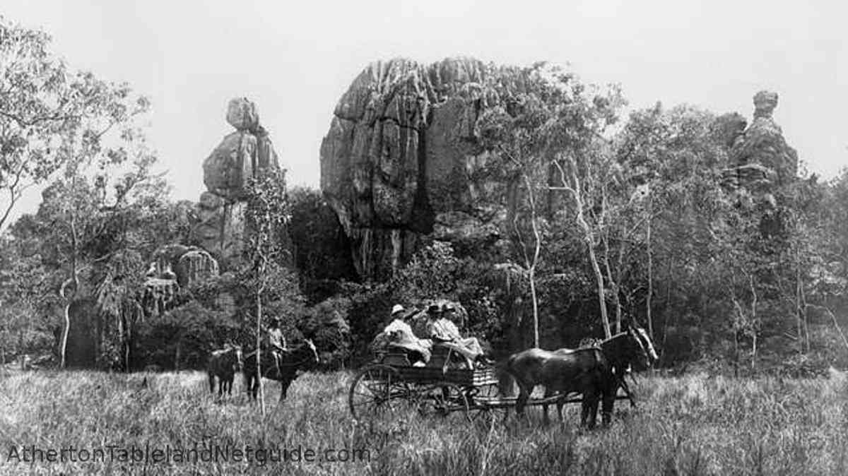 people in horse-drawn wagon in front 
      of limestone rock outcrop at Chillagoe